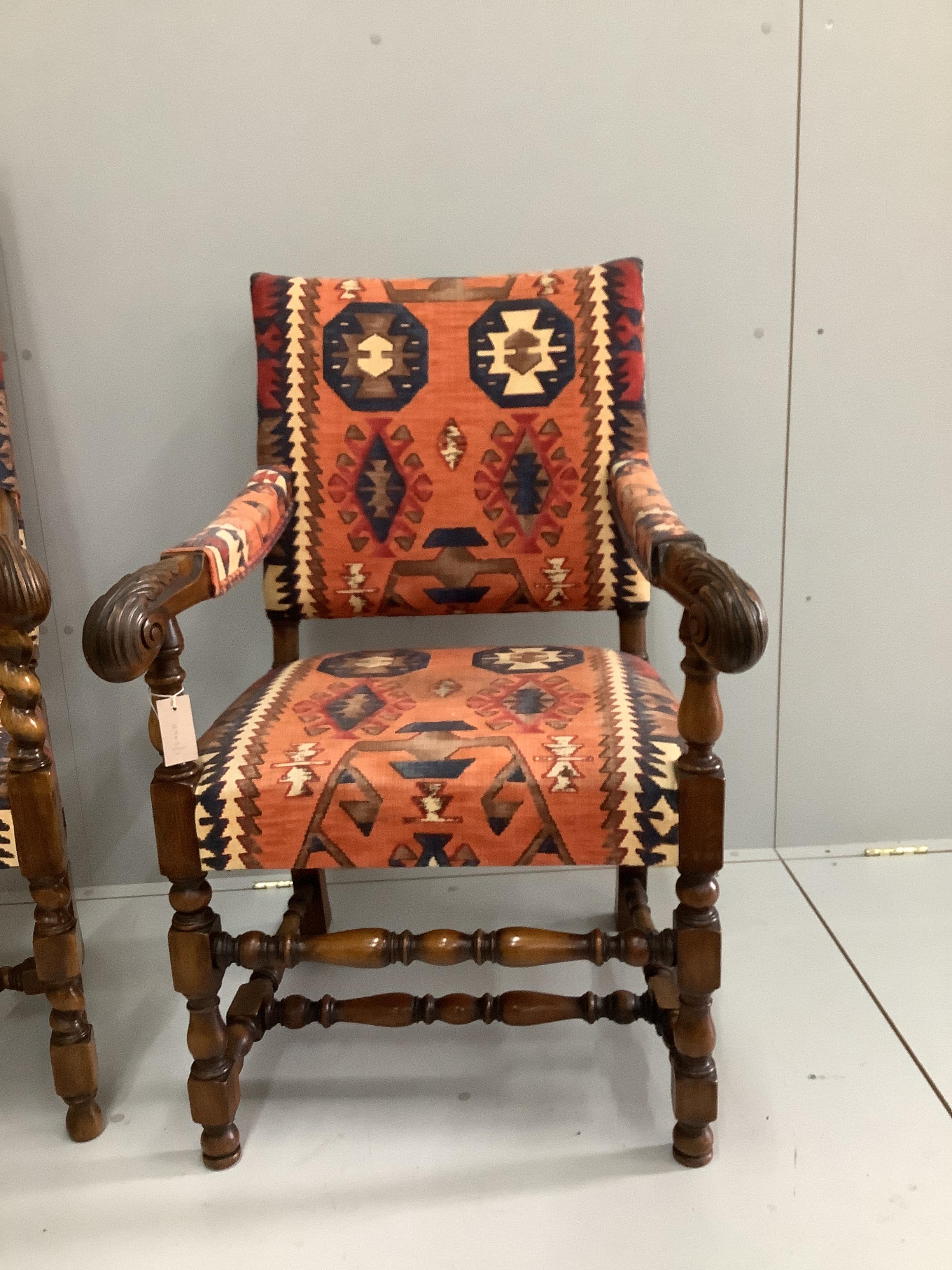 Two 1920's Jacobean Revival carved walnut elbow chairs with Kilim fabric upholstery, larger width 65cm, depth 50cm, height 124cm